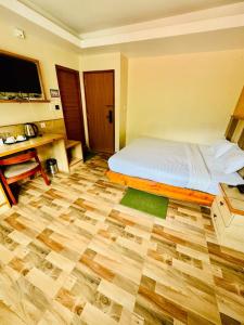 a bedroom with a bed and a wooden floor at Kwality Beach Resort in Beni Ghāt