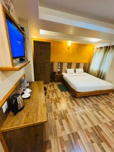 a hotel room with a bed and a flat screen tv at Kwality Beach Resort in Beni Ghāt