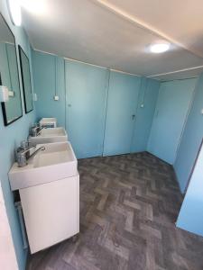 a bathroom with two sinks and blue walls at Camping by the beach Vama Veche in Vama Veche