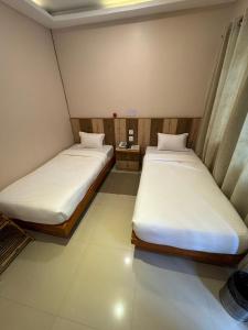 two beds in a small room with at Kwality Beach Resort in Beni Ghāt