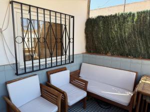 two chairs and a bench on a patio at Vecino de Alcazaba Casa Eco in Almería