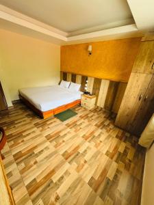 a bedroom with a bed and a wooden floor at Kwality Beach Resort in Beni Ghāt