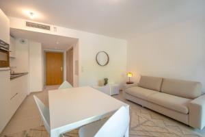 een witte woonkamer met een bank en een tafel bij Les demeures d'Oscar in Saint-Tropez