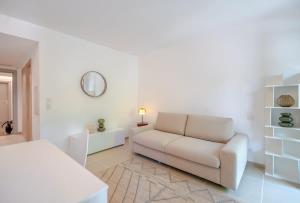 een witte woonkamer met een bank en een tafel bij Les demeures d'Oscar in Saint-Tropez