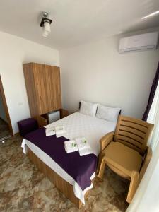 a small bedroom with a bed and a chair at Hotel Prestige Beach in Costinesti
