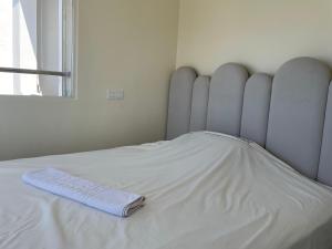 塔马里斯Cosy Studio Sea View in Casablanca的一张白色的床,上面有一条毯子 更多13张照片