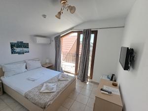 a bedroom with a bed and a large window at Vilele Liliana in Mamaia Sat/Năvodari