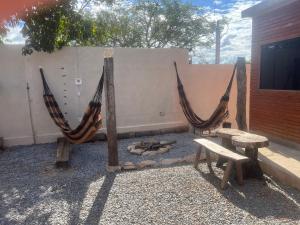 a group of hammocks next to a wall with a bench at Flats Ribeiro in Alto Paraíso de Goiás