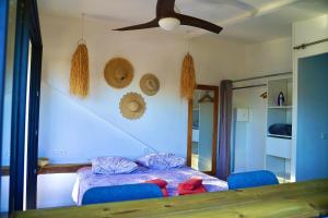 a bedroom with a bed and a ceiling fan at Lodge Palmiste, Escale tropicale in Étang-Salé