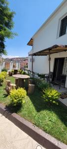 a patio with a picnic table and an umbrella at Vila Arbër 7 in Pogradec