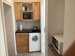 a small kitchen with a washing machine and a microwave at Apartment Feldkirchen in Feldkirchen an der Donau