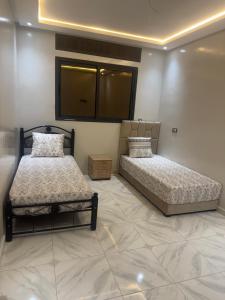 two beds in a room with a tiled floor at حاضرة محيط in Jerifat +13 photos