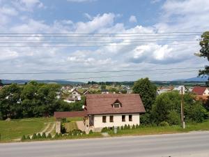 a small white house on the side of a road at Apartmán Bobrov 2 in Bobrów