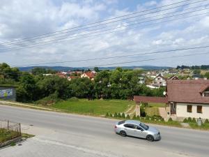 a silver car driving down a road at Apartmán Bobrov 2 in Bobrów +4 photos