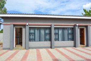 una casa pequeña con muchas ventanas en Living Waters Guest House, en Gaborone