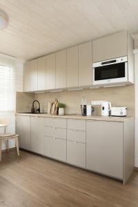 a kitchen with white cabinets and a microwave at Houseboat Daisy in Prague