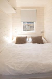 a large white bed in a room with a window at Houseboat Daisy in Prague +9 photos