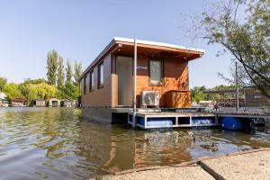 a tiny house on a dock in the water at Houseboat Daisy in Prague