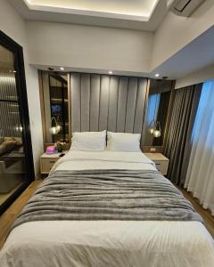 1 cama grande en un dormitorio con 2 ventanas en Luxury apartment at Park McKinley West suite 1, en Manila