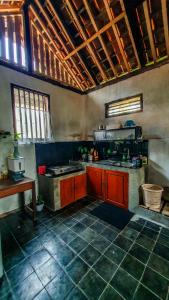 a kitchen with red cabinets and a counter in it at Rumah Gaharu - Wetan 