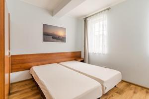 a bedroom with a white bed and a window at Apartamenty Zefir in Rowy