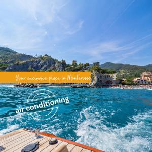 a boat in the water with a view of a beach at La Casa del Gigante Luxury Collection in Monterosso al Mare