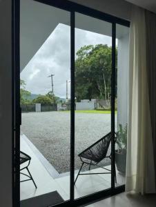 an open glass door with two chairs outside at Espaço para Hóspedes LieblingsEcke in Pomerode