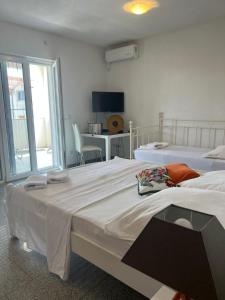a bedroom with two beds and a desk with a television at Apartment Vodice - Lovric in Vodice