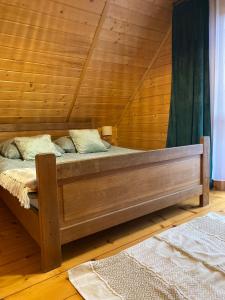 a bed in a room with a wooden ceiling at CISÓWKA in Sadowie