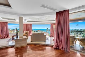 a living room with red curtains and a view of the ocean at Royal Savoy Sharm El Sheikh in Sharm El Sheikh