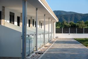 an external view of a white building with a walkway at Maistrali Elia in Sarti