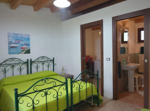 een slaapkamer met een groen bed en een badkamer bij Sa Stella E Monti in Marrùbiu
