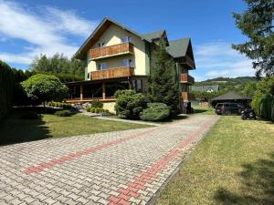 a house with a brick path in front of it at Relax in Polańczyk
