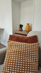 a brown and white pillow on a couch at CMG Studio 3 Petit Bois Place Ducale in Charleville-Mézières +34 photos