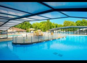 a large swimming pool with blue water and umbrellas at Mobil-home 4-6 personnes in Aureilhan