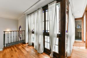 a room with a wooden floor and a large window at Feel Hostels City Center in Málaga