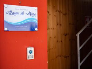 罗戈·格兰德阿夸迪马勒住宿加早餐旅馆的红墙边的标牌上有一个温度计