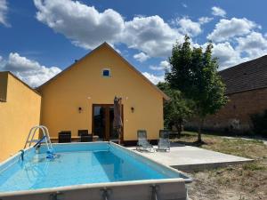 a large swimming pool in front of a house at Tengelice-ház in Réde
