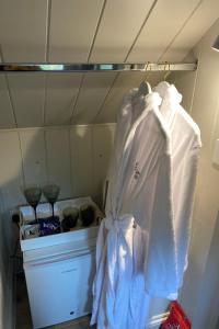 - un placard avec des chemises blanches suspendues à un portant dans l'établissement Stamping Cottage near Isles of Scilly Park and Ride, à Penzance