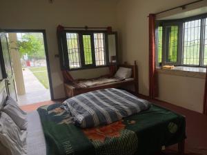 a bedroom with a bed and a mirror and windows at Budget Rooms with Garden by Galiyat Inn Balakot in Bālākot