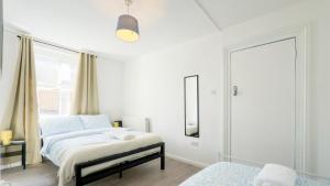 a white bedroom with a bed and a window at London Bridge Stays in London
