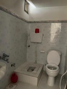 a small bathroom with a toilet and a sink at Budget Rooms with Garden by Galiyat Inn Balakot in Bālākot
