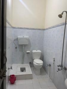 a small bathroom with a toilet and a shower at Budget Rooms with Garden by Galiyat Inn Balakot in Bālākot
