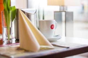 una taza de café sentada en una mesa con una servilleta en Montana-Hotel Ellwangen, en Ellwangen