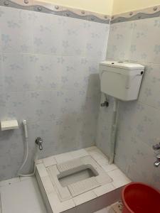 a small bathroom with a toilet in the floor at Budget Rooms with Garden by Galiyat Inn Balakot in Bālākot