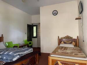 a bedroom with a bed and a clock on the wall at Budget Rooms with Garden by Galiyat Inn Balakot in Bālākot +21 photos