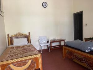 a bedroom with two beds and a table and a chair at Budget Rooms with Garden by Galiyat Inn Balakot in Bālākot