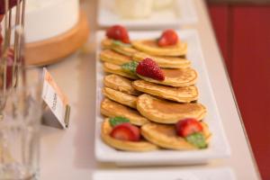 a tray of pancakes with strawberries on top of it at Montana-Hotel Ellwangen in Ellwangen +25 photos