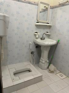 a bathroom with a sink and a toilet and a mirror at Budget Rooms with Garden by Galiyat Inn Balakot in Bālākot