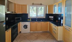 a kitchen with a washing machine and a sink at Villa QuintaBella in Sivota